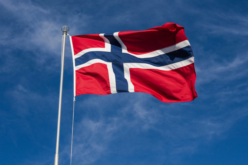 Det norske flagget som vaier i vinden på en flaggstang